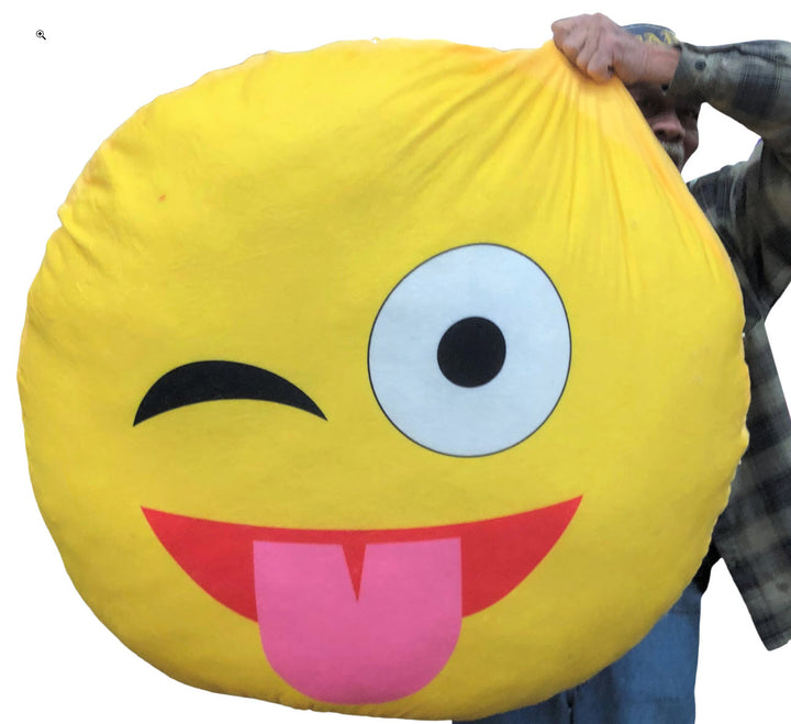 Giant stuffed emoji pillow face with tongue stuck out licking it's lips